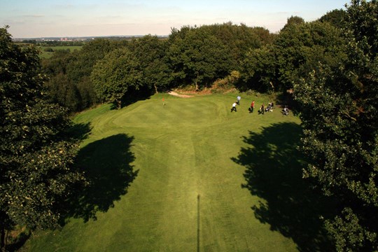 Looking towards the 10th green from above surrounded by trees