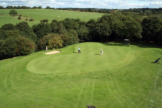 The 12th green with open countryside in the background