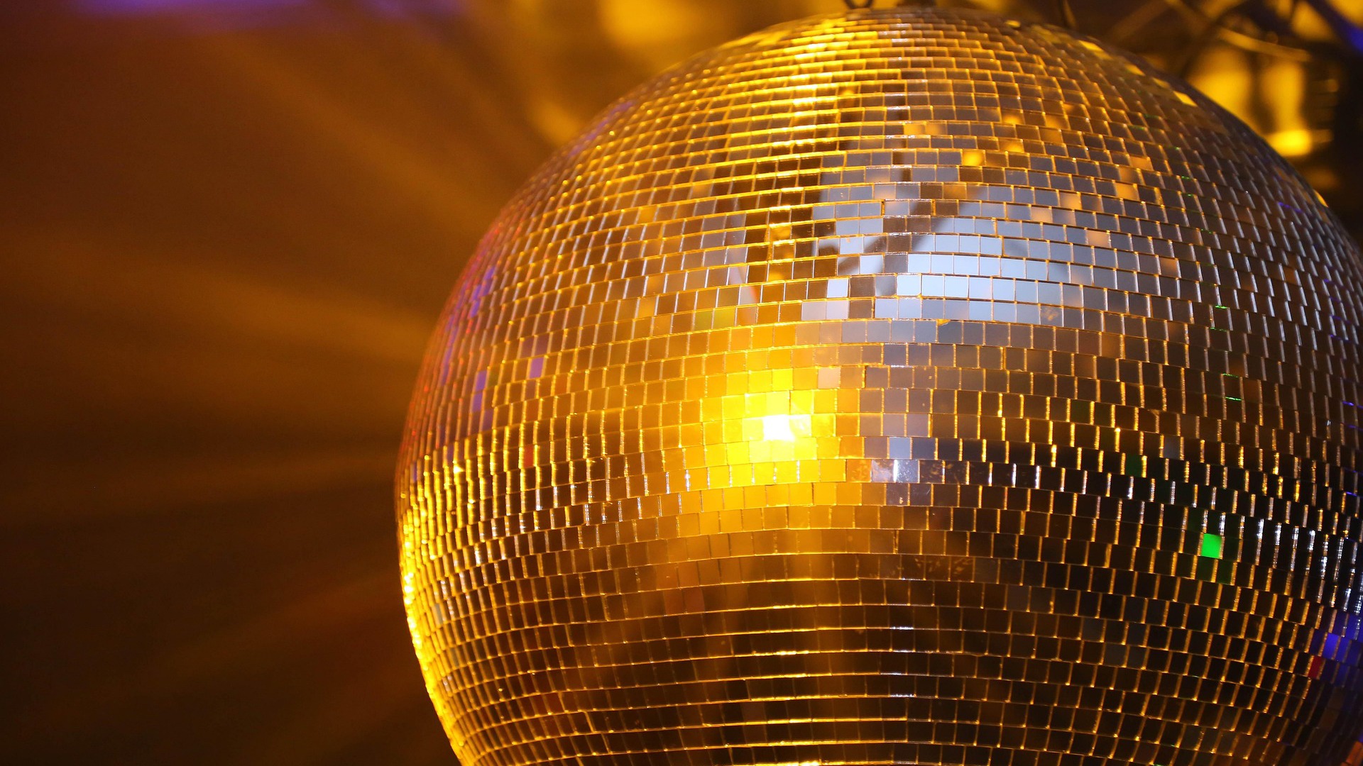 Mirror ball reflecting yellow light.