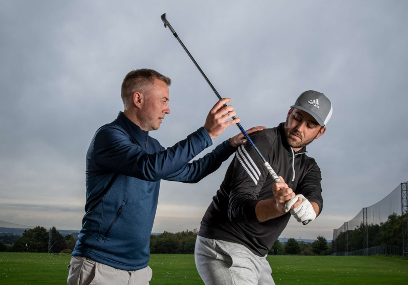 PGA Professional Richard Hedley and a golfer at The Manor's driving range, Richard is instructing the golfer.