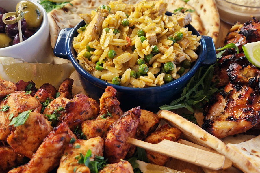 The Greek sharing board at The Manor Leeds; Chicken Souvlaki Skewers, Lamb Kofta, Grilled Halloumi, Greek-Style Chicken Thighs, Garlic & Thyme Roasted Potatoes, Flatbreads / Pittas, Roasted Vegetables, Classic Greek Salad, and Orzo Pasta Salad.