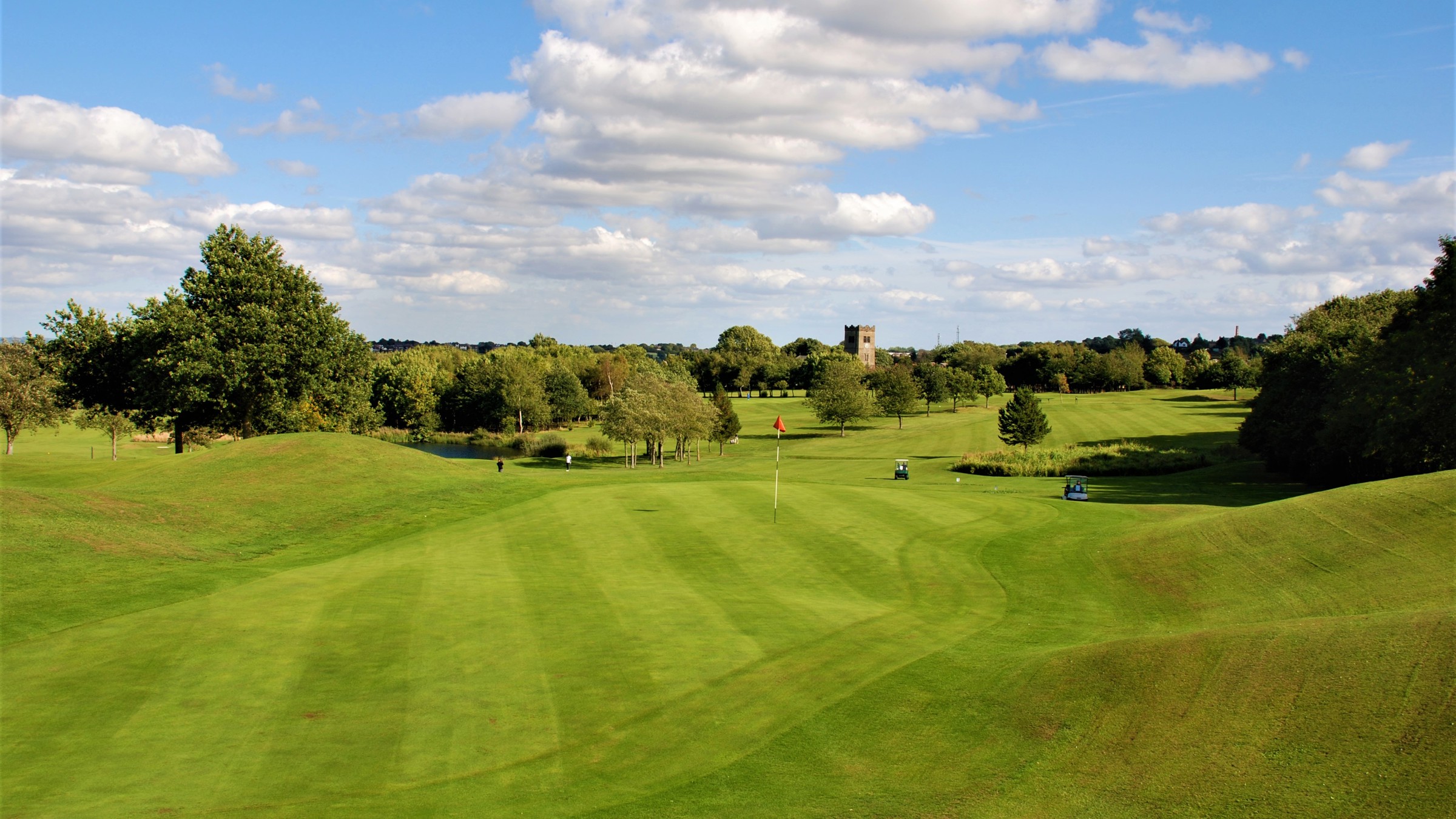 A view of 18th green at The Manor golf course. The tower of St Paul's church, Drighlington, can be seen just above the trees in the background.