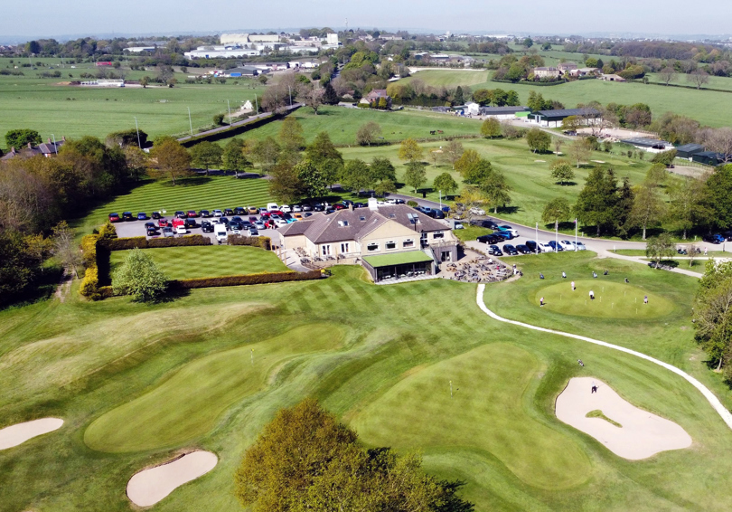 An aerial photo of the rear aspect of The Manor main building. The golf course can be seen in the foreground.
