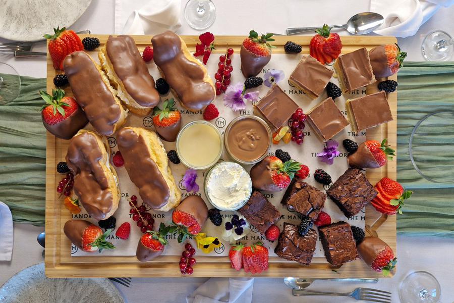 The Chocolate One sharing board at The Manor Leeds; chocolate brownies,  chocolate-dipped strawberries, chocolate eclairs and millionaire shortbread.