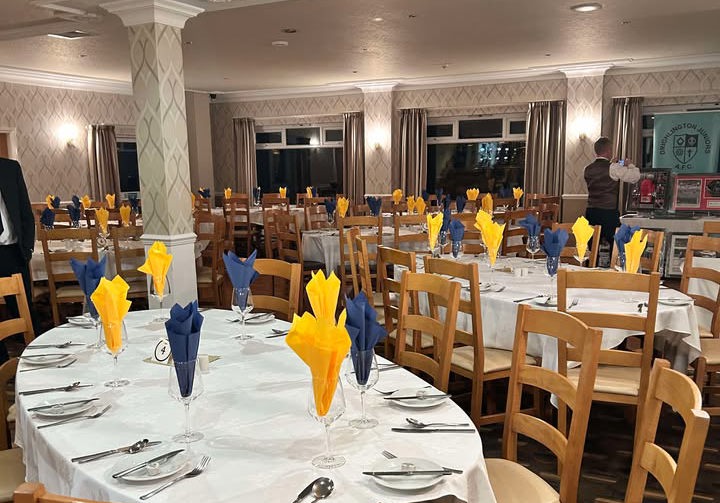 Dining tables in The View at The Manor set with yellow and blue napkins.