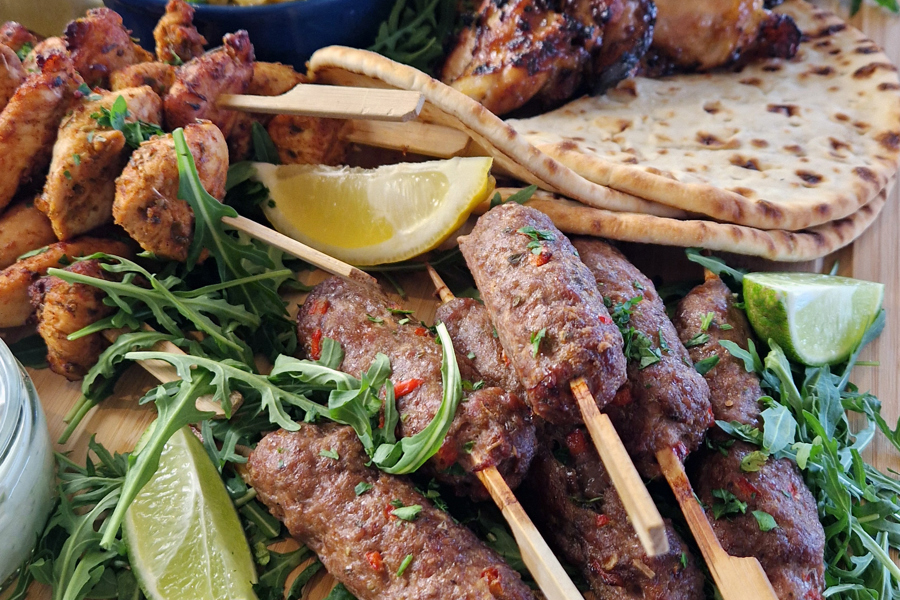 The Greek sharing board at The Manor Leeds; Chicken Souvlaki Skewers, Lamb Kofta, Grilled Halloumi, Greek-Style Chicken Thighs, Garlic & Thyme Roasted Potatoes, Flatbreads / Pittas, Roasted Vegetables, Classic Greek Salad, and Orzo Pasta Salad.