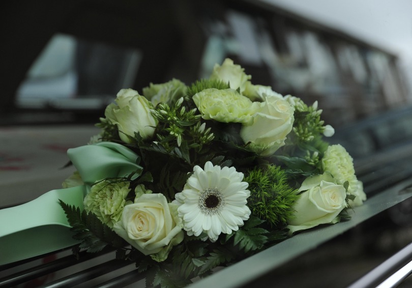 Cream and white flowers on a black casket.