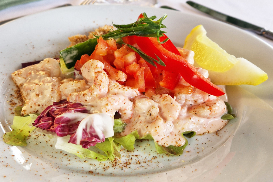 Prawn cocktail on a plate, placed on a formal dining table.