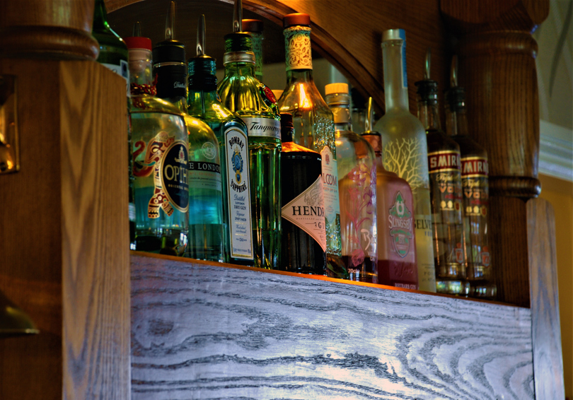 Bottle of spirits on a shelf behind the oak bar.