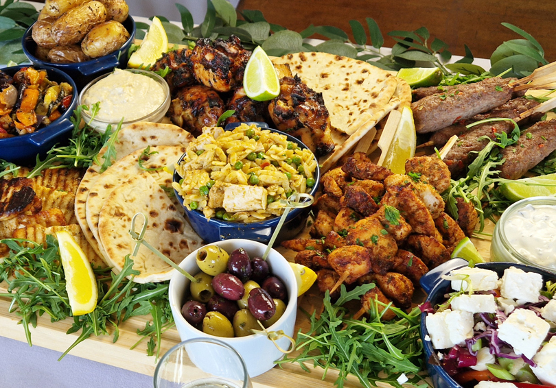 The Greek sharing board at The Manor Leeds; Chicken Souvlaki Skewers, Lamb Kofta, Grilled Halloumi, Greek-Style Chicken Thighs, Garlic & Thyme Roasted Potatoes, Flatbreads / Pittas, Roasted Vegetables, Classic Greek Salad, and Orzo Pasta Salad.
