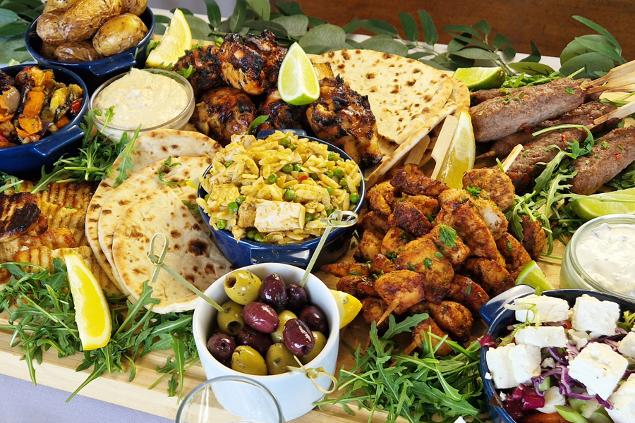 The Greek sharing board at The Manor Leeds; Chicken Souvlaki Skewers, Lamb Kofta, Grilled Halloumi, Greek-Style Chicken Thighs, Garlic & Thyme Roasted Potatoes, Flatbreads / Pittas, Roasted Vegetables, Classic Greek Salad, and Orzo Pasta Salad.