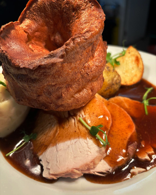 Roast dinner on a plate, Yorkshire Pudding, pork and gravy.